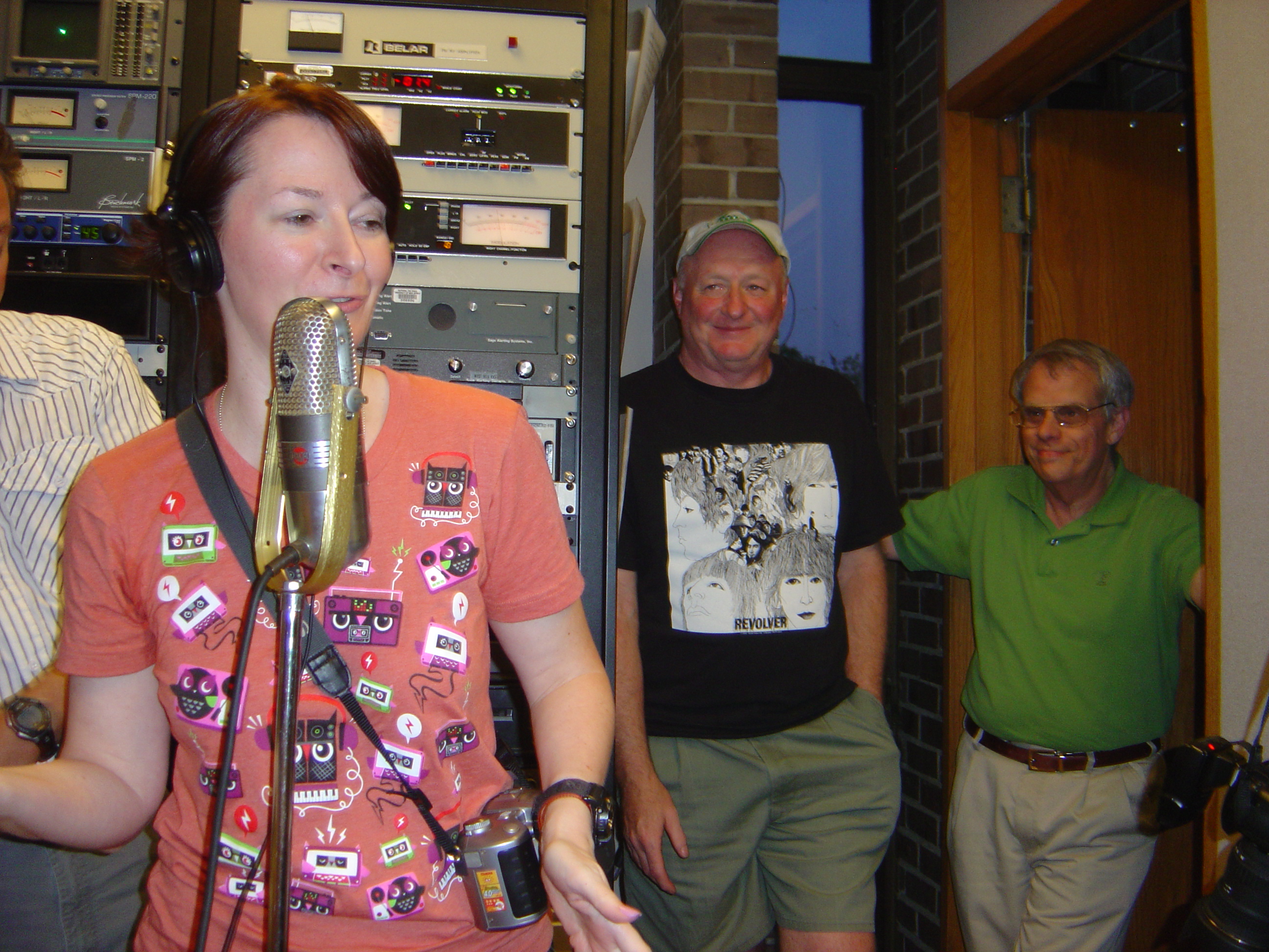 Lisa Uber at the microphone, John Cooper and Tim Espar look on.